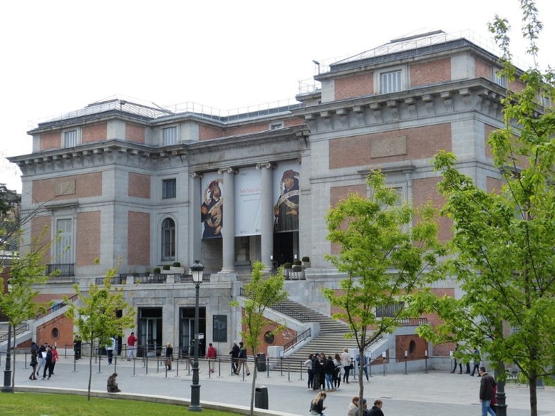 pink and white museum building with wide stairs and trees in the foreground