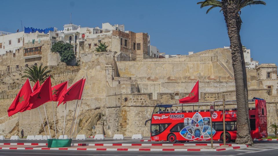 red bus in front of a stone walled city