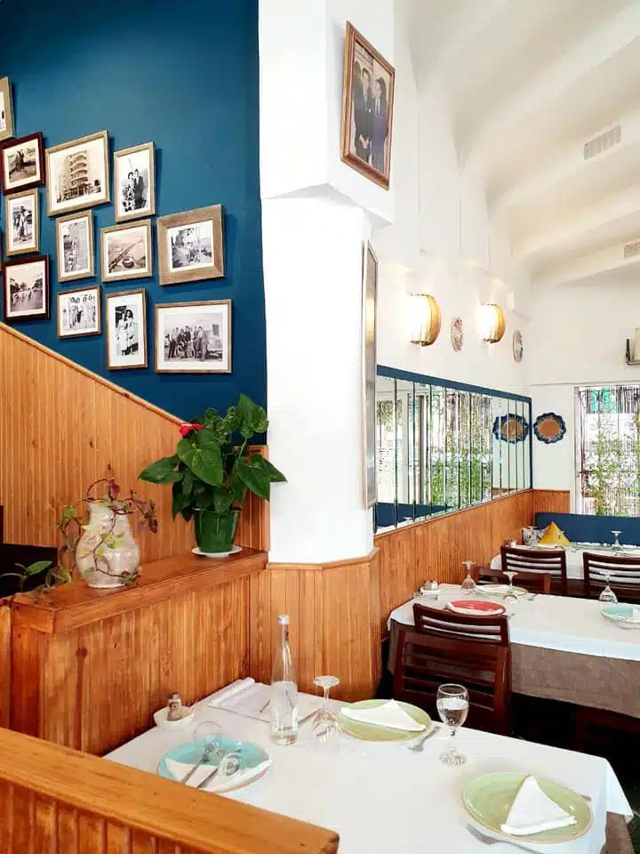 inside of a restaurant with wood panelling and tables laid with clothes and cultery