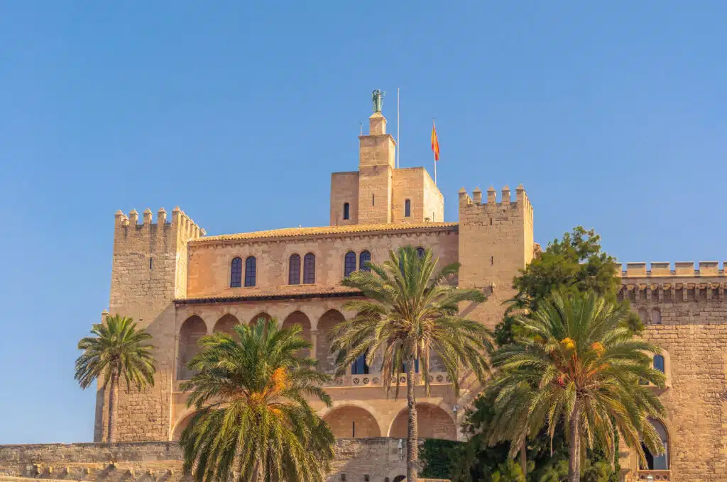 Muslim palace surrounded by palm trees and flying the Spanish flag