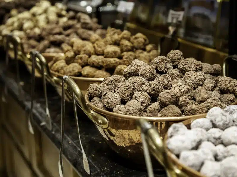 different types of chocolate truffles in large metal bowls