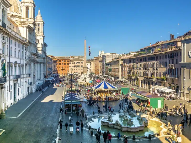 elegant square with fountains and historic buildings full of market stalls at Christmas time