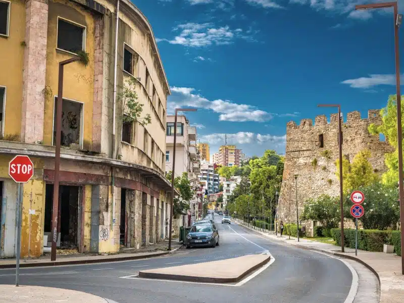 city street lined with buildings and a stone castle