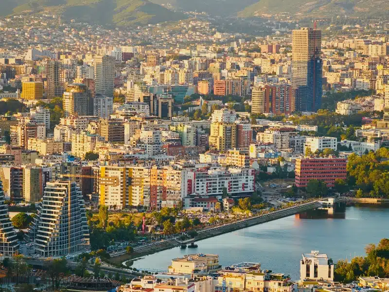 aerial view of a large city with a lake and tall buildings