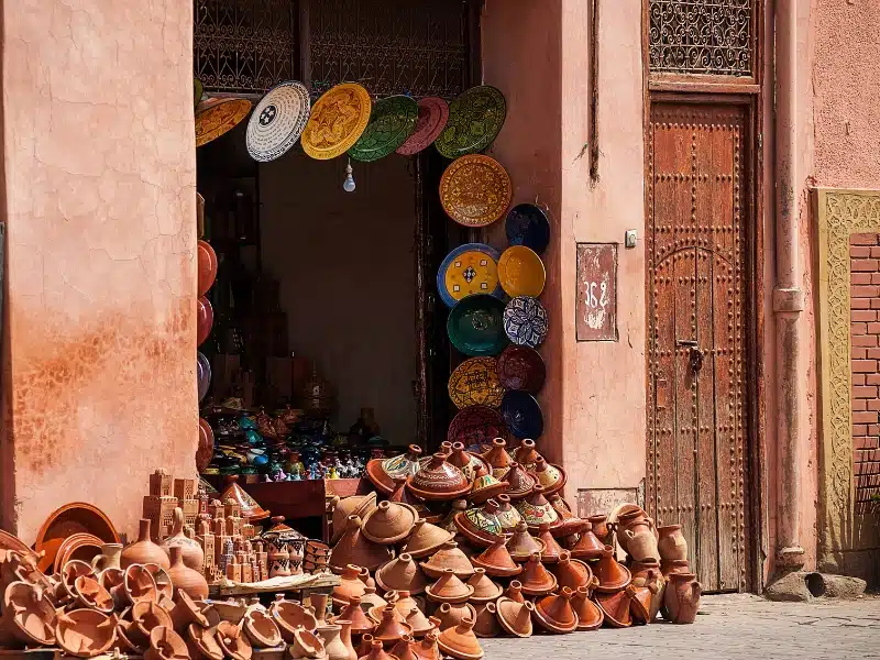 earthenware tajines and brightly colourd plates for sale outside a shop in Morocco