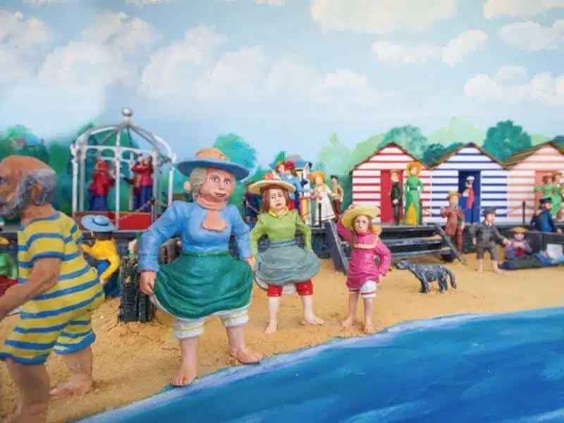 miniature models dressing in Victorian bathing costumes with model beach huts behind