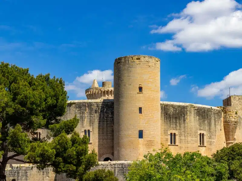 round stone castle with small windows and a round tower 