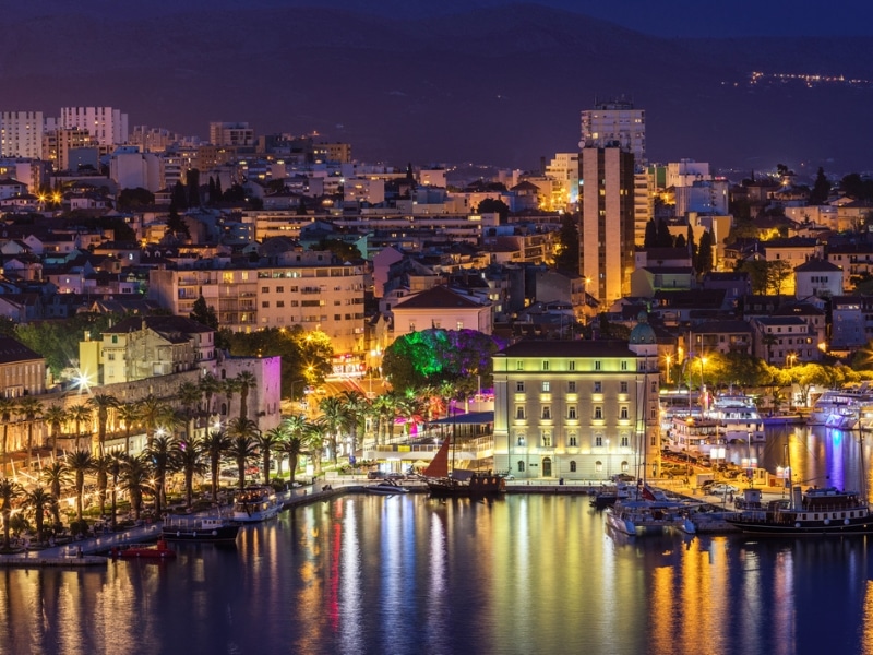 waterfront of a town lit up at night