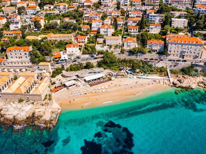 small beach backed by a town with turquoise water
