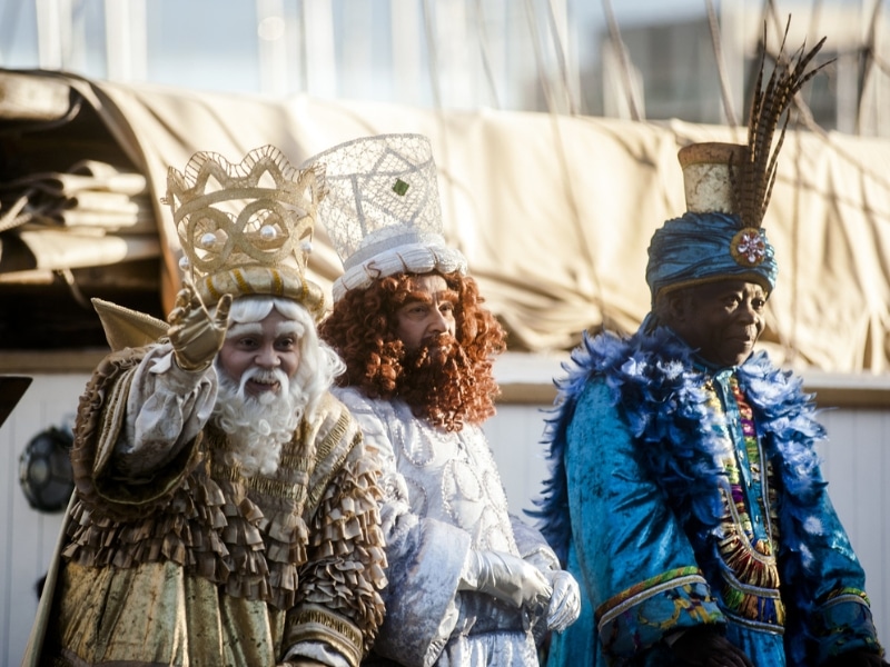 three kings dressed in gold, white and blue costumes
