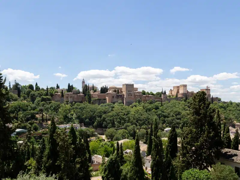 stone palace on a hillside surrounded by trees