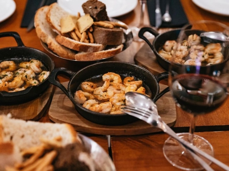 plates and bowls of tapas with glasses of wine