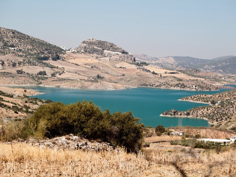 turquoise lake surrouned by mountains and olive groves
