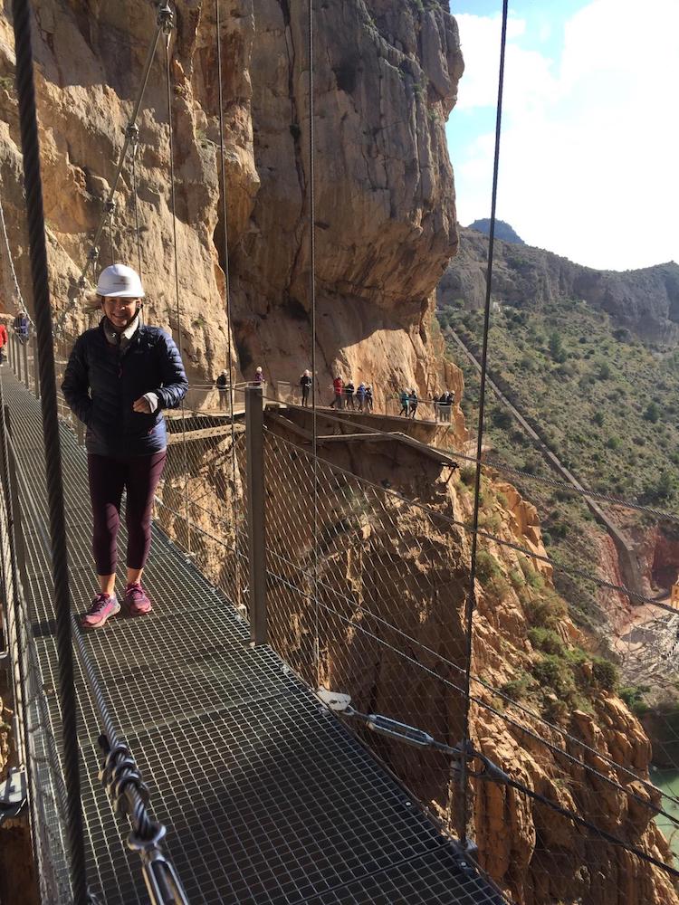 woman on a suspended walkway againsta. cliff