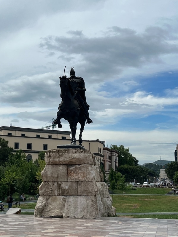 large statue of a man on a horse atop a large rocky plinth