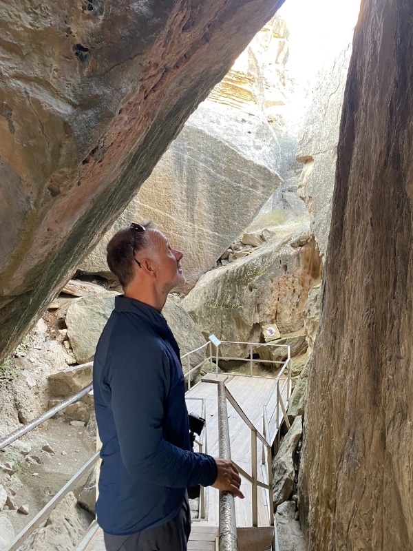 man looking at petroglyps on rocks