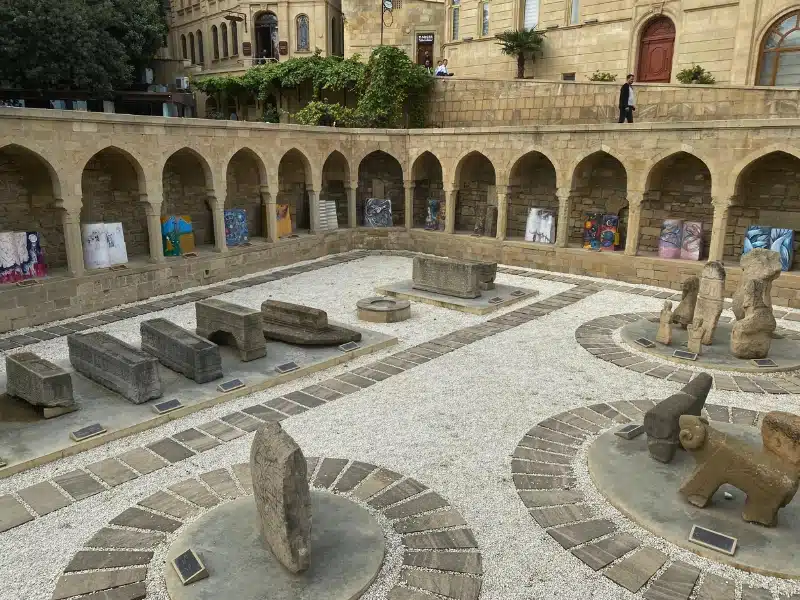 stone build bazaaar below street level with arches on a raised outer platform and tombs in the middle