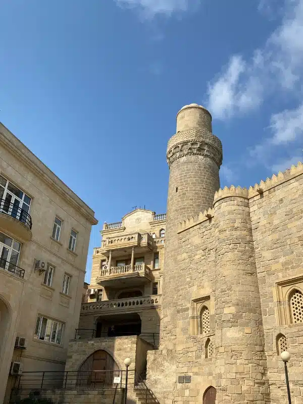 stone mosque with round minaret and balconies levels