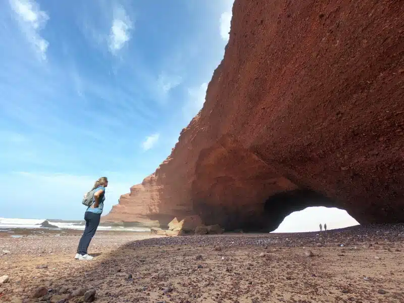 huge sandstone sea arch with a person looking on