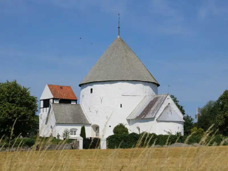 round white church with a thatched roof and other square buildings attached