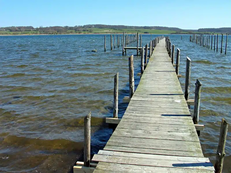 long wooden jettty with posts above the sea