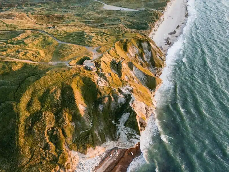 aerial view of large sand dunes meeting the sea