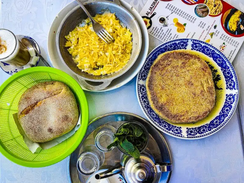 plates of Moroccan food - bread, omlet, and a tray of mint tea