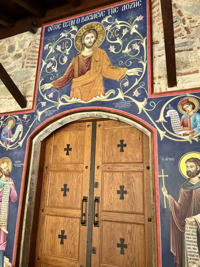 painting of a holy person on a brick wall around a wooden door