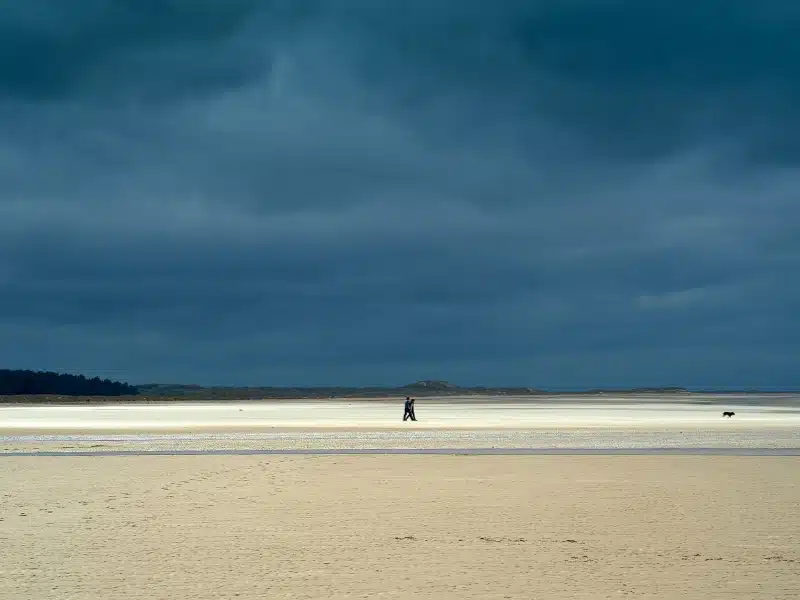 hige sandy beach and a dark moody sky