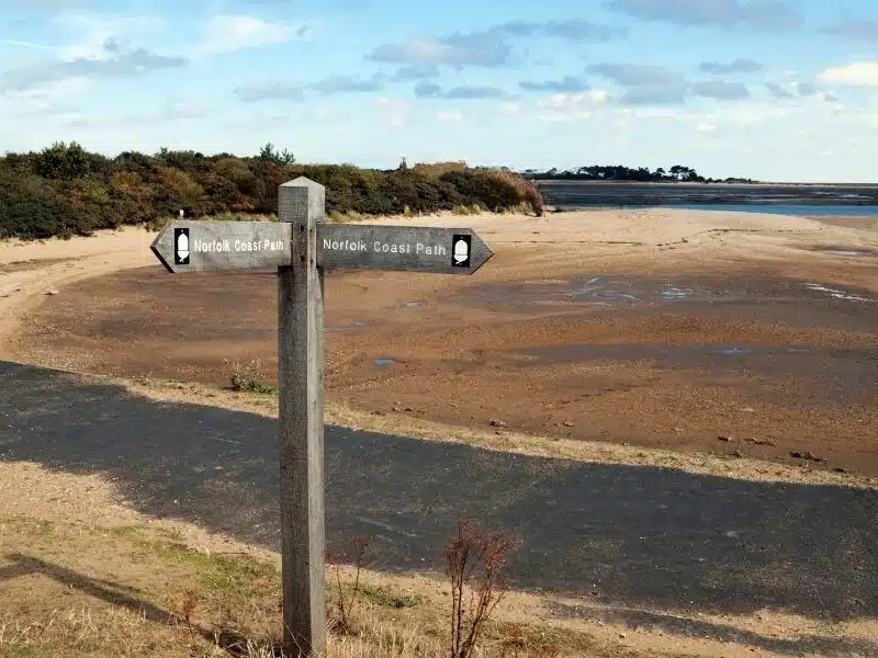 Norfolk coast path sign on the beach with the pine woods in the background