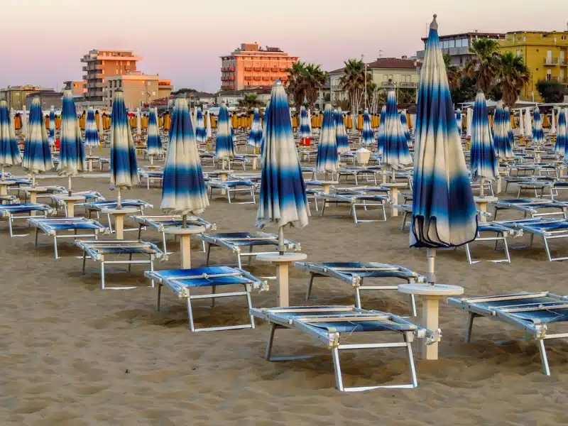 beach with blue and white sunbeds and umberellas