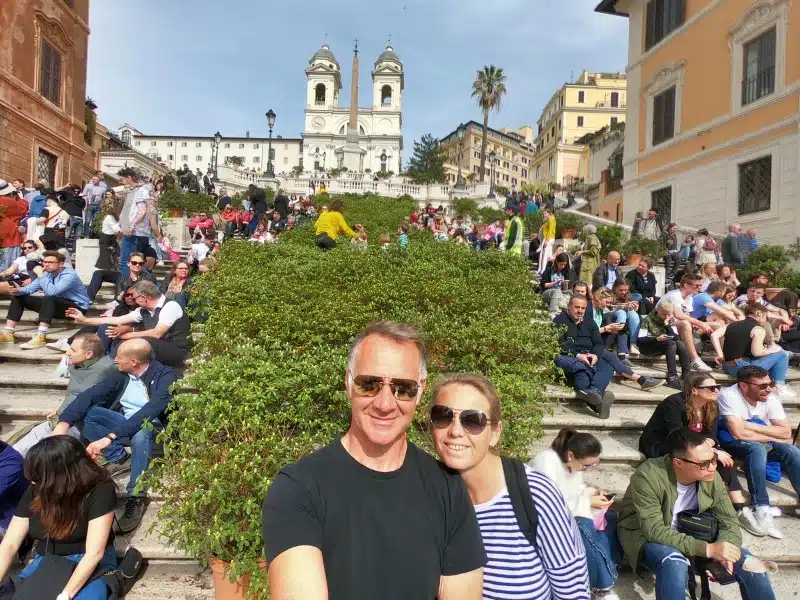 crowds of people sitting and standing on travertine steps in Rome