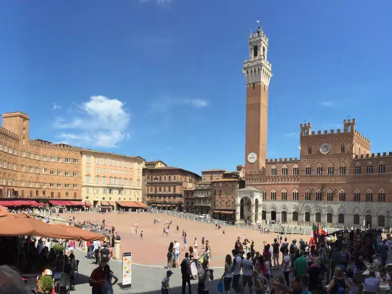 large circular square with red brick buildings anda crenellated tower