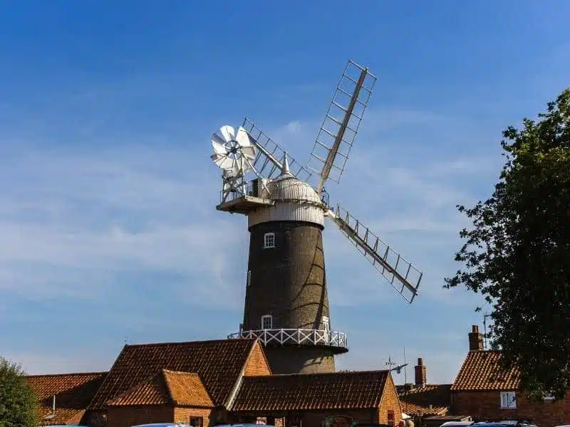 black and white windmill surrouned by cottages