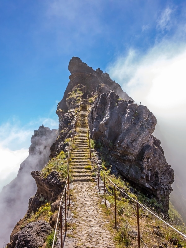 rocky stairway with rope holds ascending a tall peak