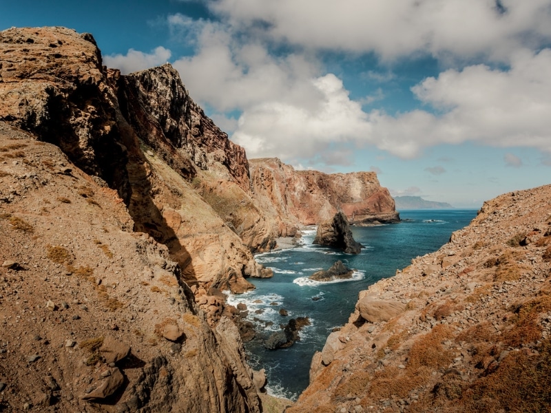 bare rocky cliffs and rocks in the sea below the cliffs