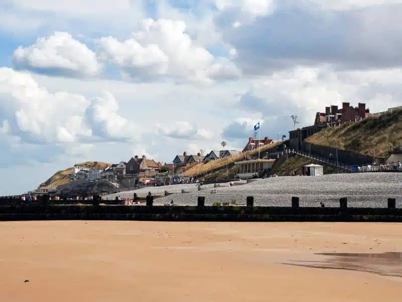 beach with a small clif behind and a town