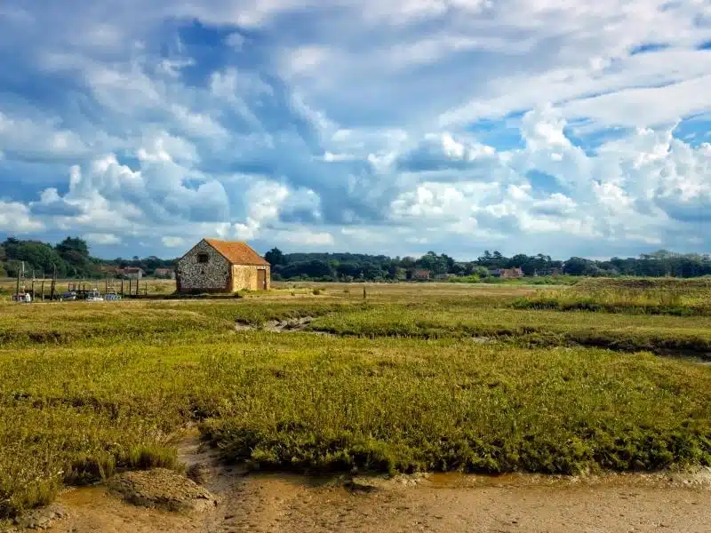 flint building with red roof in sea marshes