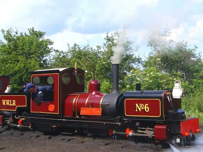 small red and black steam train puffing smoke