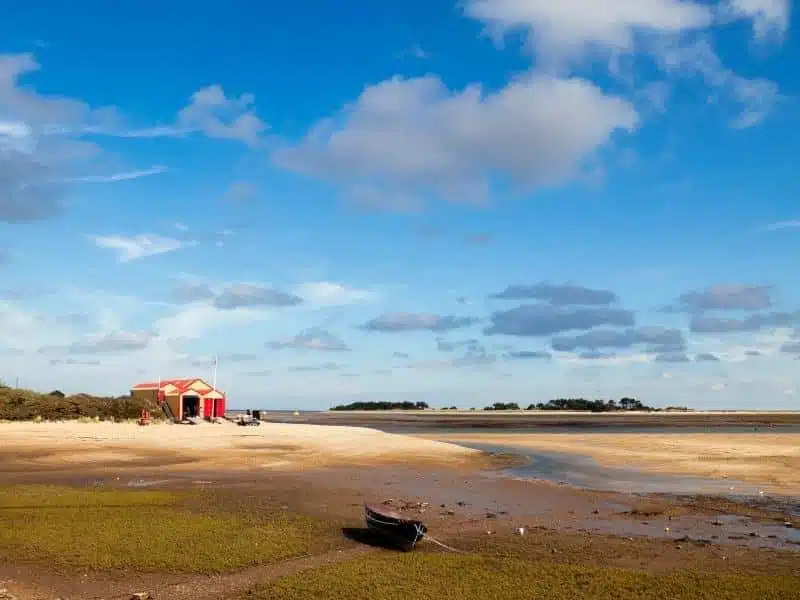 large beach with a red and cream building in the distance