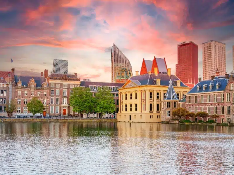 historic buildings along a canal with tall modern buildings rising behind