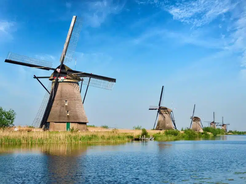 Netherlands rural lanscape with windmills lined up along a canal