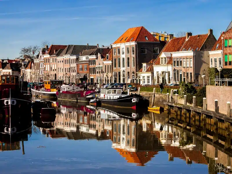 traditional canal boats moored by a row of houses