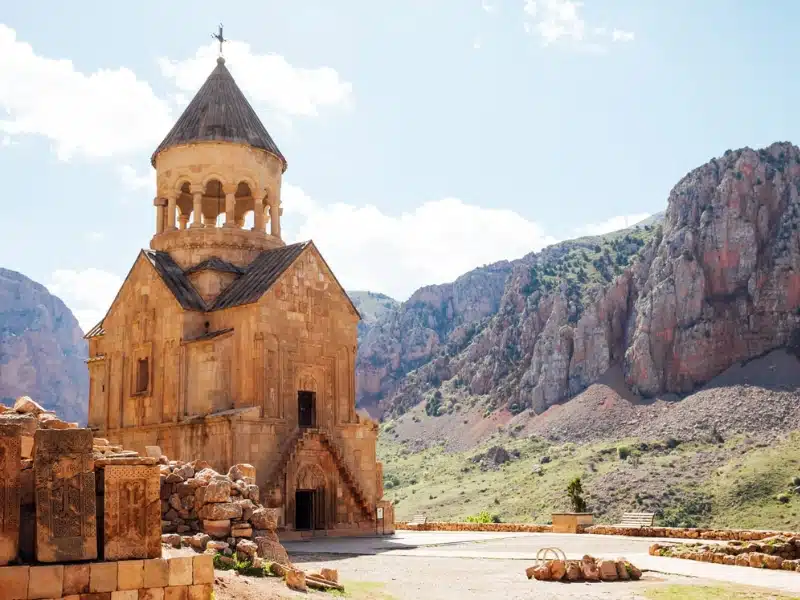 orange stone monastery surrouned by red rock hills