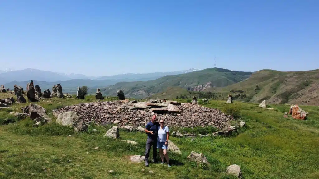 stone circle surrounded by grass with mountains in the distance