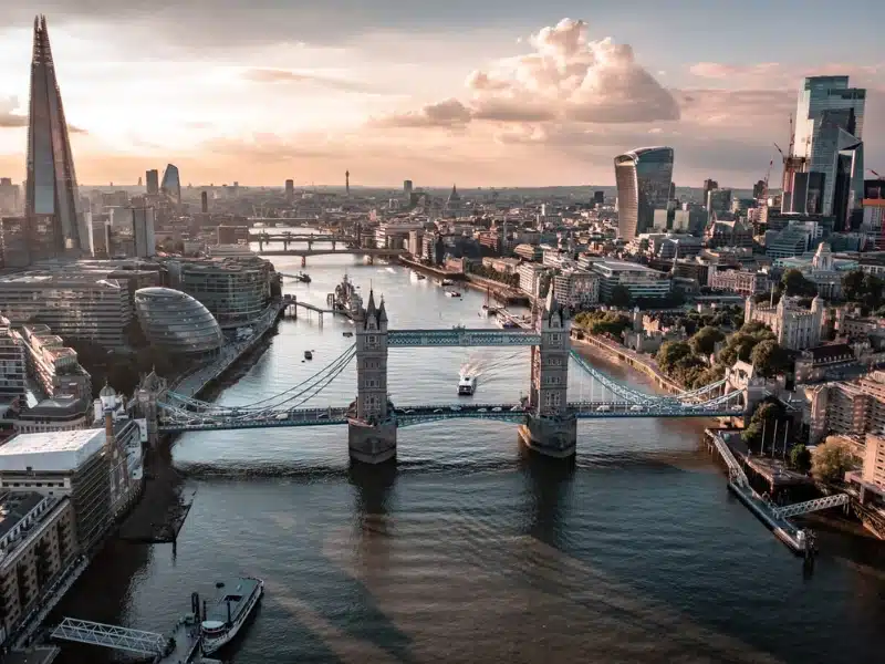 city skyline of a river, tower bridge and skyscrapers at dusk