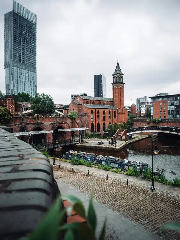 canal in a British city with a bridge and historic buildings and a new glass skyscraper in the distance