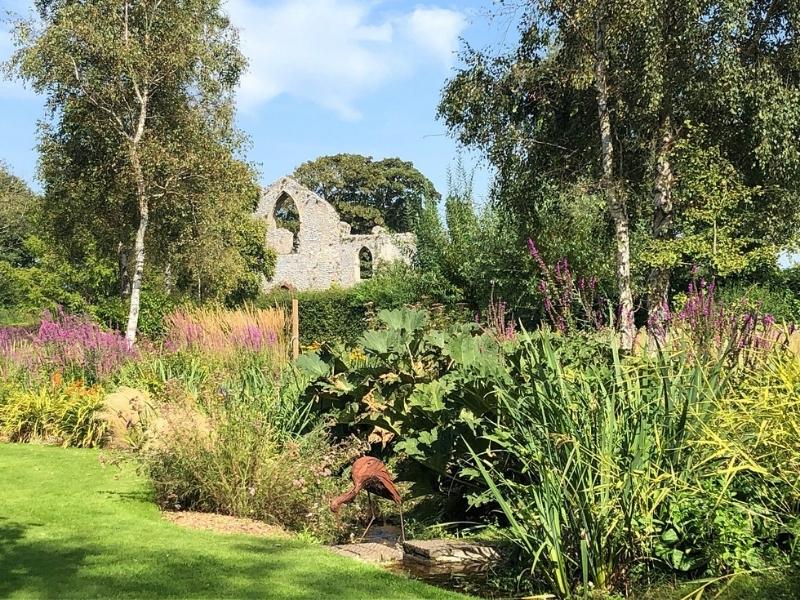 colourful gardens with a ruin in the distance