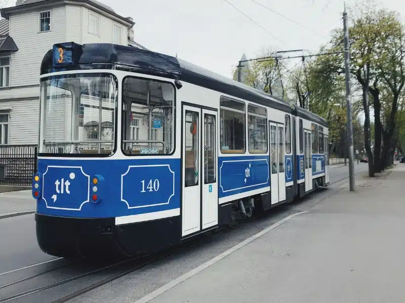 black, blue and white tram on a street in Tallinn Estonia