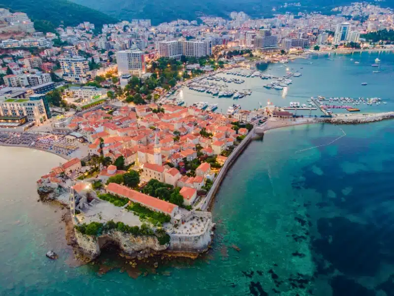 Budva city lights from Montenegro seen from above. Night view. Drone old town Budva at night.